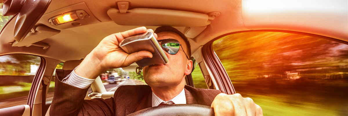A man drinking alcohol while driving